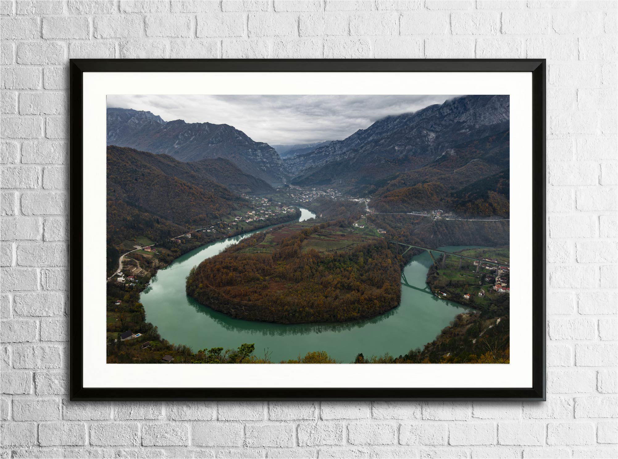 Mise en situation du tirage "Méandre sur la Neretva" encadré sur un mur, photographie d’art imprimée sur papier Fine Art.